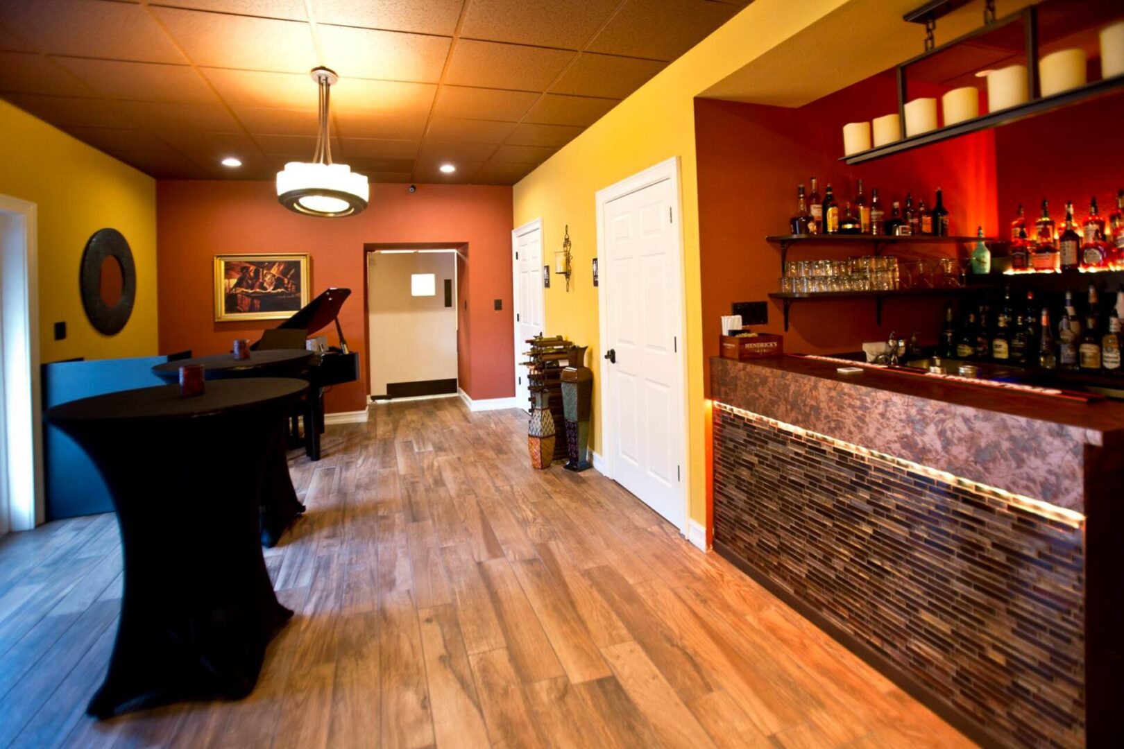 Mustard yellow and pale orange-painted cocktail room with a grandpiano and a bar