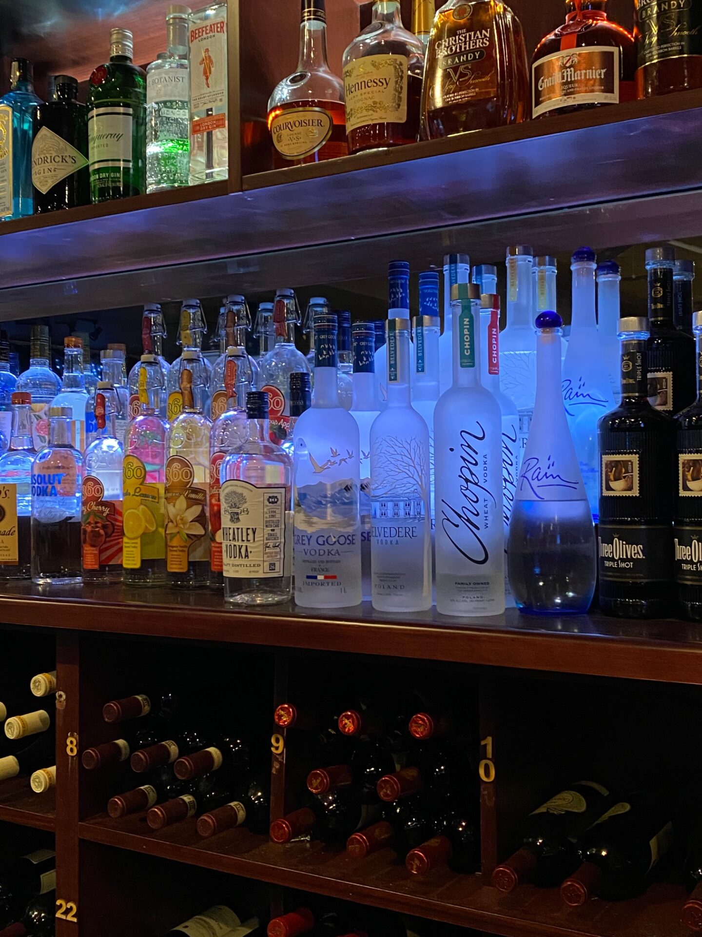 Bar shelves full of bottles of different alcoholic drinks