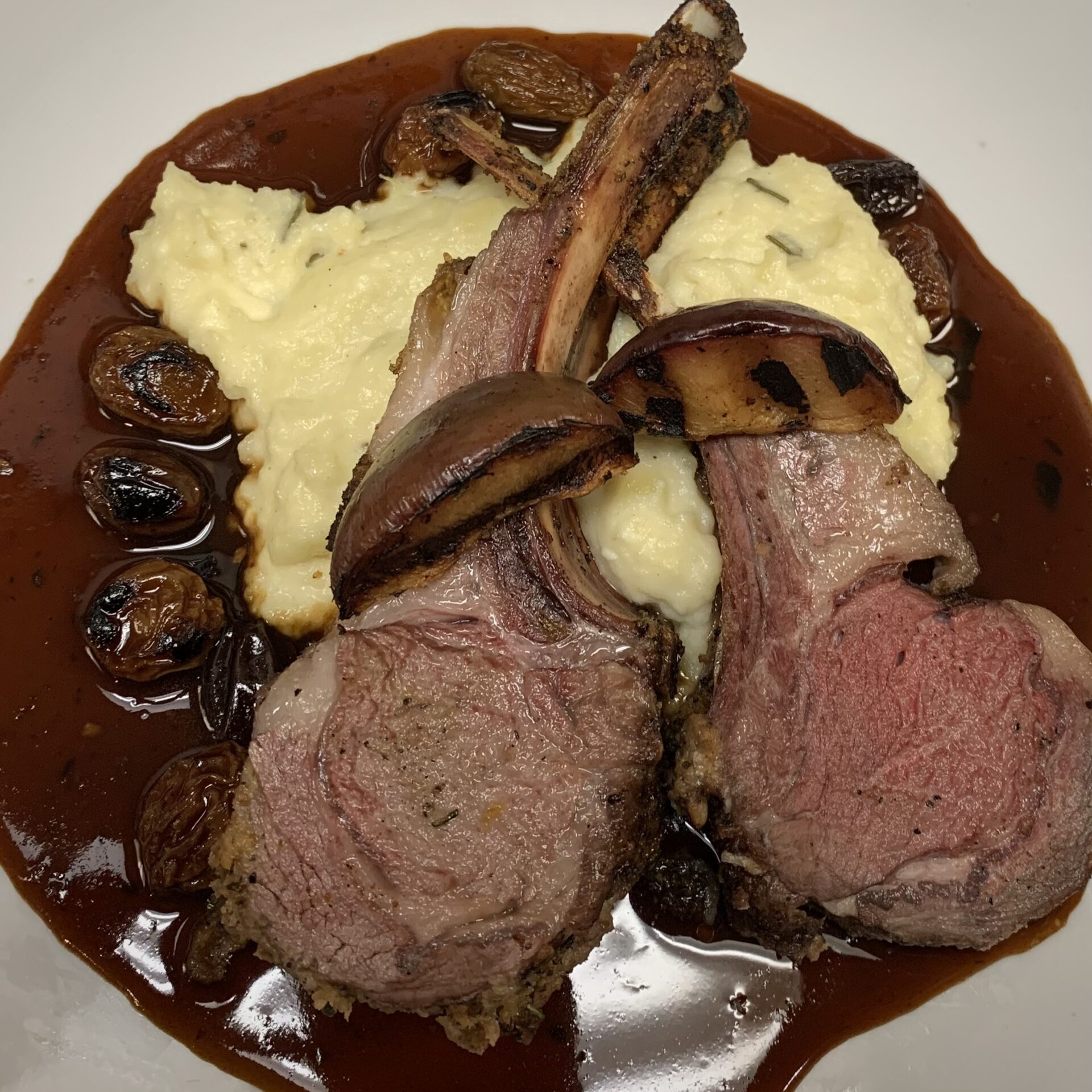 Lamb chops on top of mashed potatoes with brown sauce