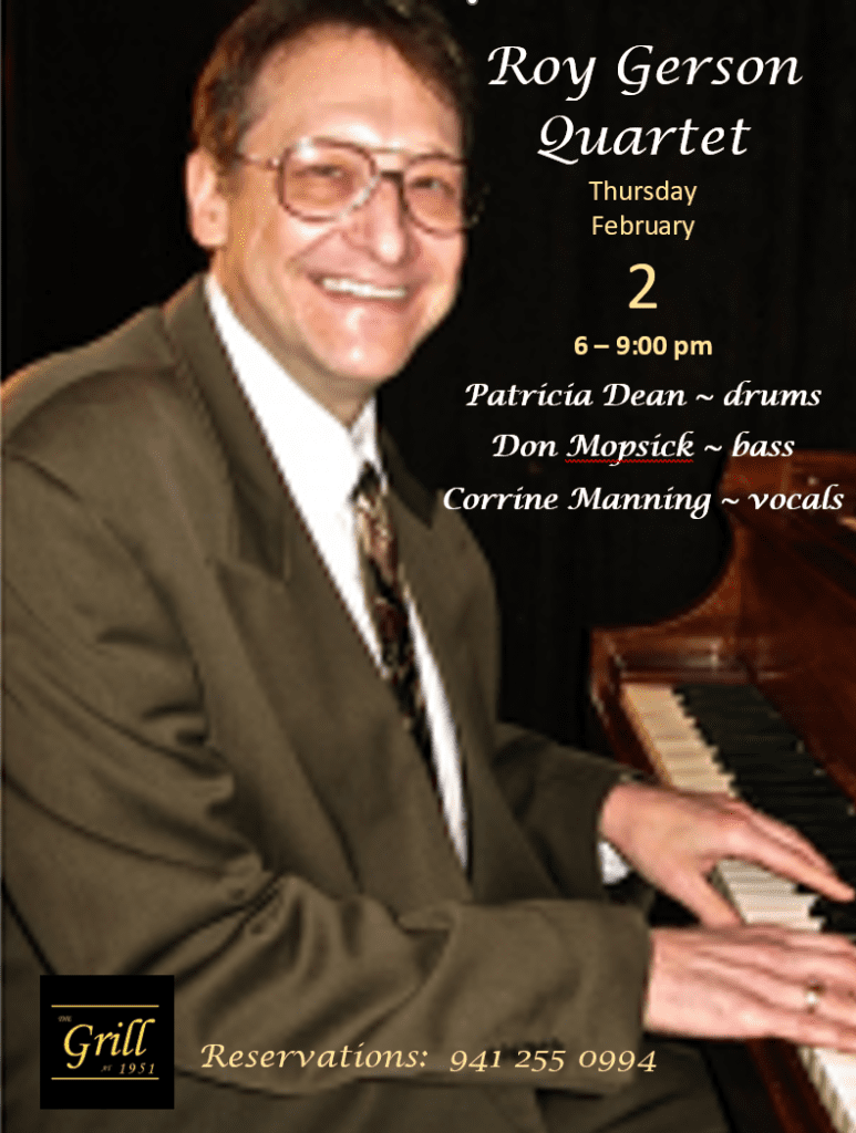 A man in glasses and suit playing the piano.