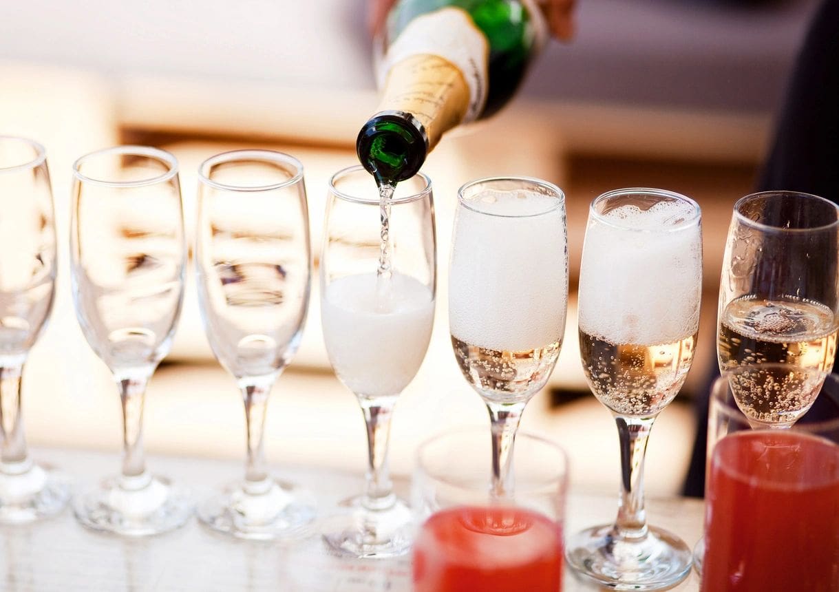 Champagne foaming in a row of flutes